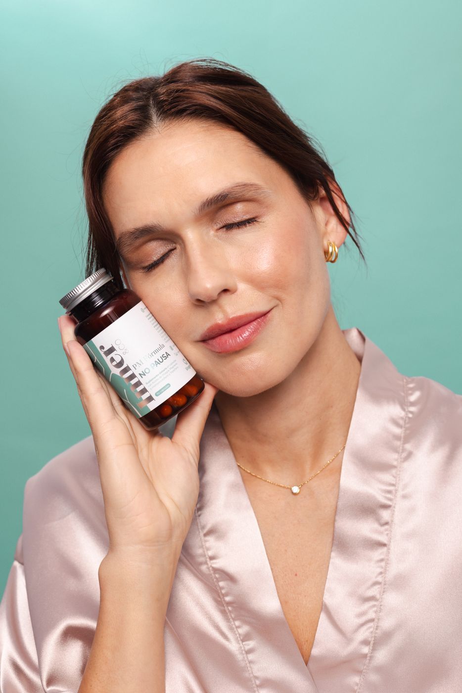 Mujer con los ojos cerrados y el frasco de la fórmula PM